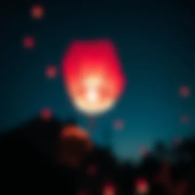 Close-up of a pink sky lantern being released, illuminated against the night sky