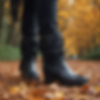 Seasonal display of black fringe boots with autumn leaves